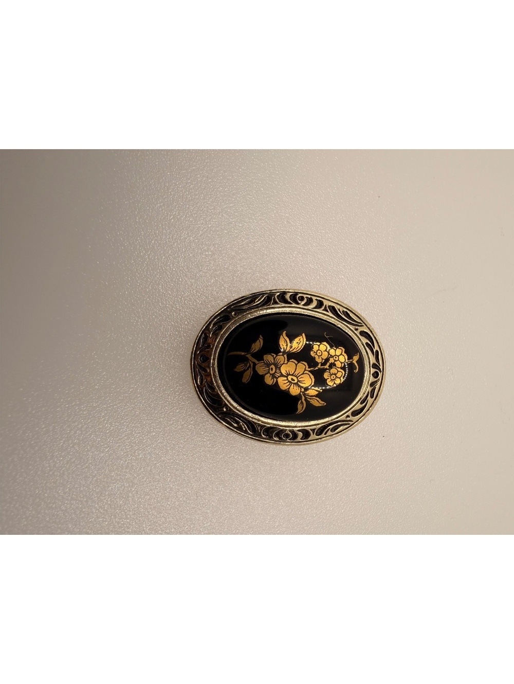 Black oval floral brooch